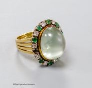 A modern 750 yellow metal, pale green cabochon stone, emerald and diamond set oval dress ring, size
