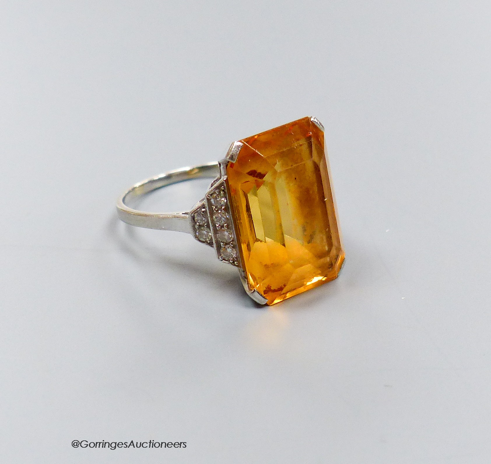 A white metal and emerald cut yellow topaz set dress ring, with diamond set shoulders, size N,