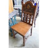 An Arts and Crafts oak and embossed copper hall chair.