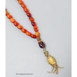 A single strand amber bead necklace, with gilt metal pendant, 36cm, gross weight 12 grams.