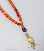 A single strand amber bead necklace, with gilt metal pendant, 36cm, gross weight 12 grams.