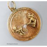 A 14k yellow metal and diamond set circular pendant, depicting articulated figures of an angel and