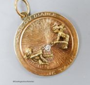 A 14k yellow metal and diamond set circular pendant, depicting articulated figures of an angel and