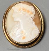 An early 20th century yellow metal mounted oval cameo shell brooch, carved with the bust of a lady