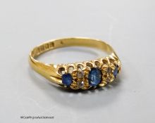 An Edwardian 18ct gold, three stone sapphire and diamond chip set ring, size R, gross weight 3.1