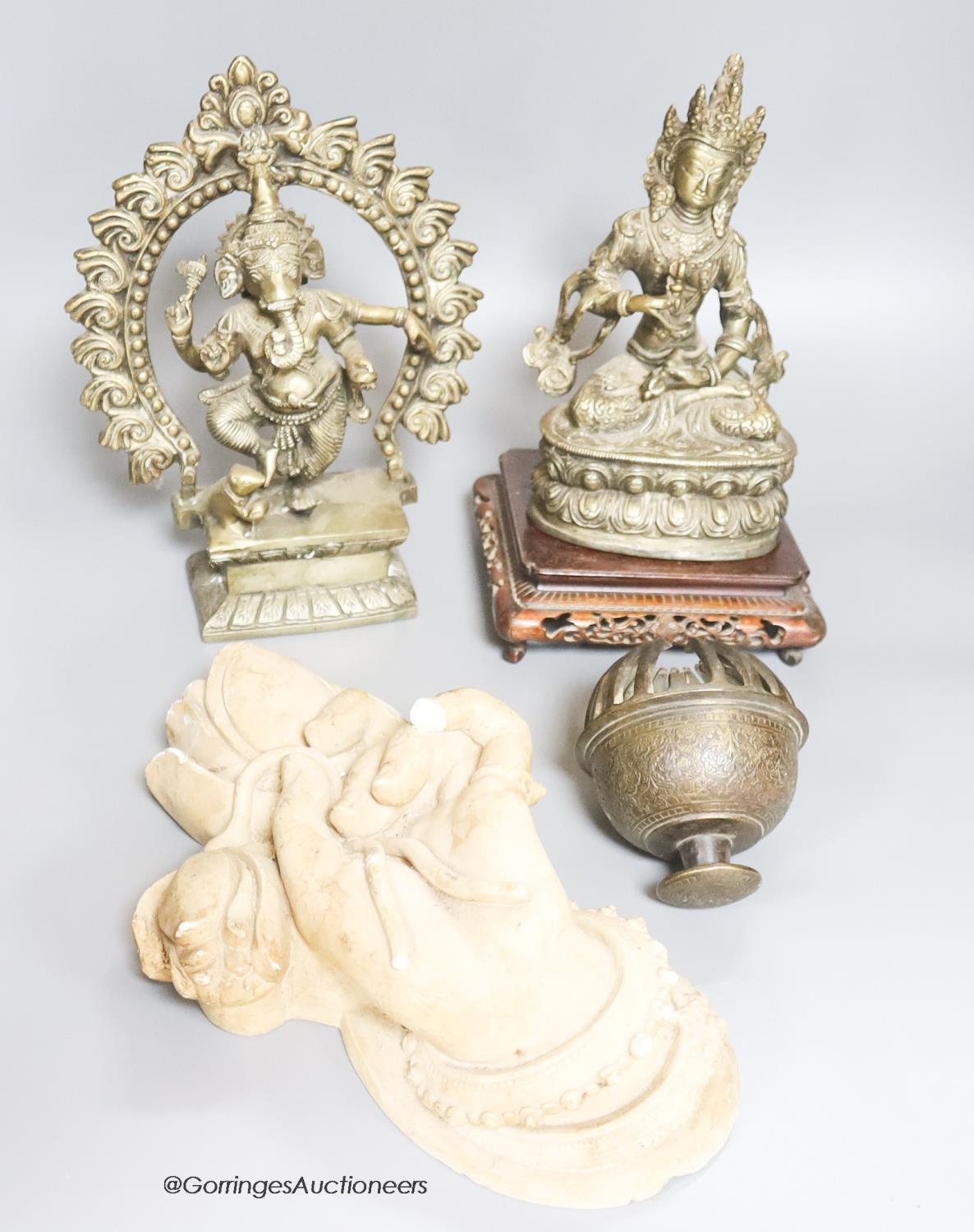 Two reproduction brass figures of Indian deities, a bell, a carved stand and a plaster plaque,