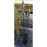 A pair of three Louis XV style brass fire implements and matching stand
