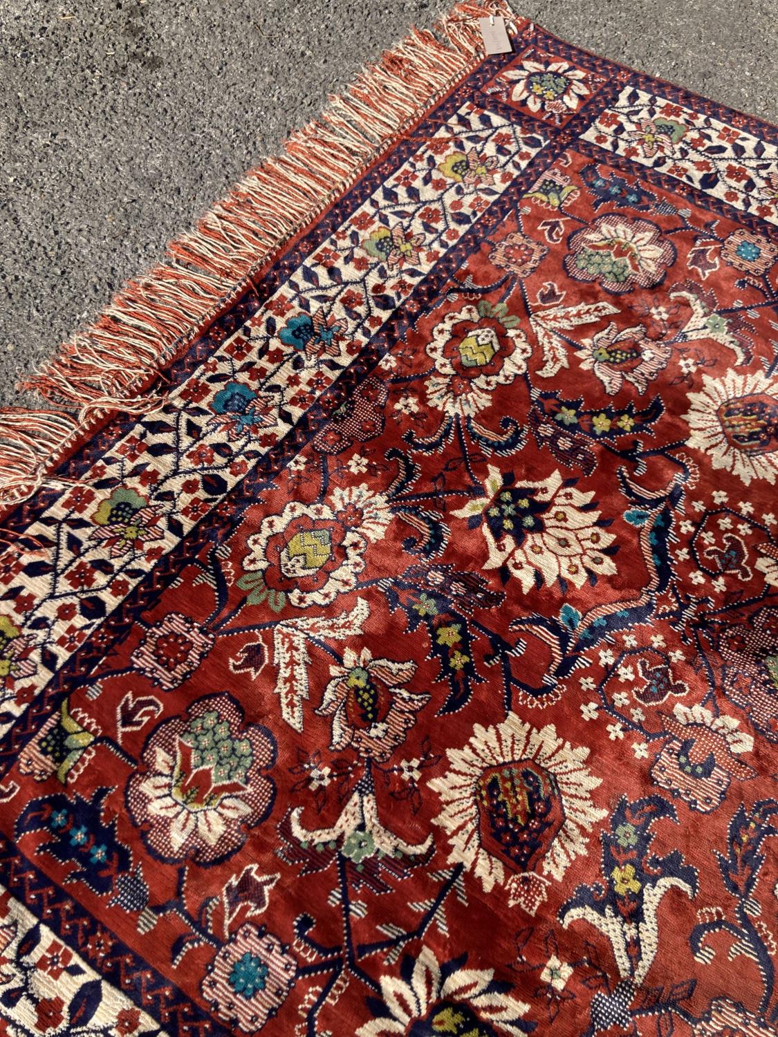 A large embroidered silk rug with a claret red ground interspersed with symmetrical foliate - Image 4 of 5