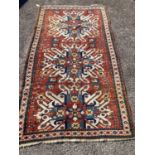 An early 20th century Caucasian “Eagle” Kazak brick red ground rug with triple medallion (altered)