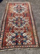 An early 20th century Caucasian “Eagle” Kazak brick red ground rug with triple medallion (altered)