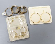 Four assorted 9ct rings, 13.5 grams and three pairs of 9ct hoop earrings in original packaging.