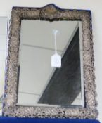 A large Edwardian repousse silver mounted easel mirror with pierced scrolling border, Henry