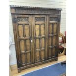 An 18th century style panelled oak triple wardrobe. W-154, D-48, H-193cm.