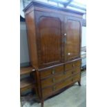 A George IV mahogany linen press, with a pair of hinged panelled doors over two short and two long