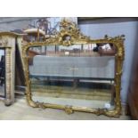 A Victorian style gilt framed wall mirror with pierced surmount and scrolling foliate border, W.