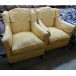 A pair of Victorian square framed armchairs, upholstered in gold damask, on carved legs and