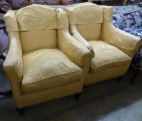 A pair of Victorian square framed armchairs, upholstered in gold damask, on carved legs and