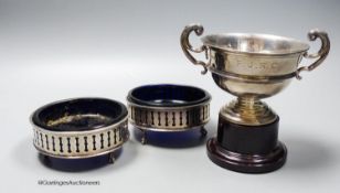 A pair of George V pieced silver small circular dishes with blue glass liners, 10cm and a silver