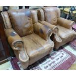 A pair of tan leather armchairs, W.94cm D.94cm H.90cm (one arm holed)