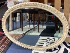 A decorative painted oval wall mirror, 96 x 70 cms.