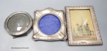 A late Victorian silver mounted circular photograph frame, 11.1cm and two later George V silver