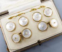 A cased six piece yellow metal (stamped 18), mother of pearl and seed pearl set circular dress stud