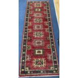 A Caucasian style red ground runner, 240 x 80cm