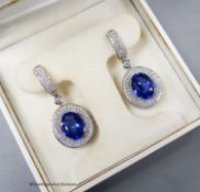 A modern pair of white metal (stamped 18k 750) tanzanite and diamond chip set oval cluster drop