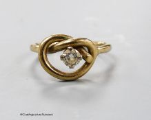 A 9ct gold and single stone diamond set 'knot' ring, size P, gross 3.3 grams.