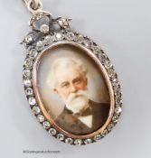 A late 19th century 900 standard gilt white metal and paste set oval pendant locket, inset with