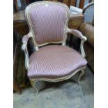 A 19th century French Louis XV style parcel gilt, cream painted fauteuil, with striped upholstery.