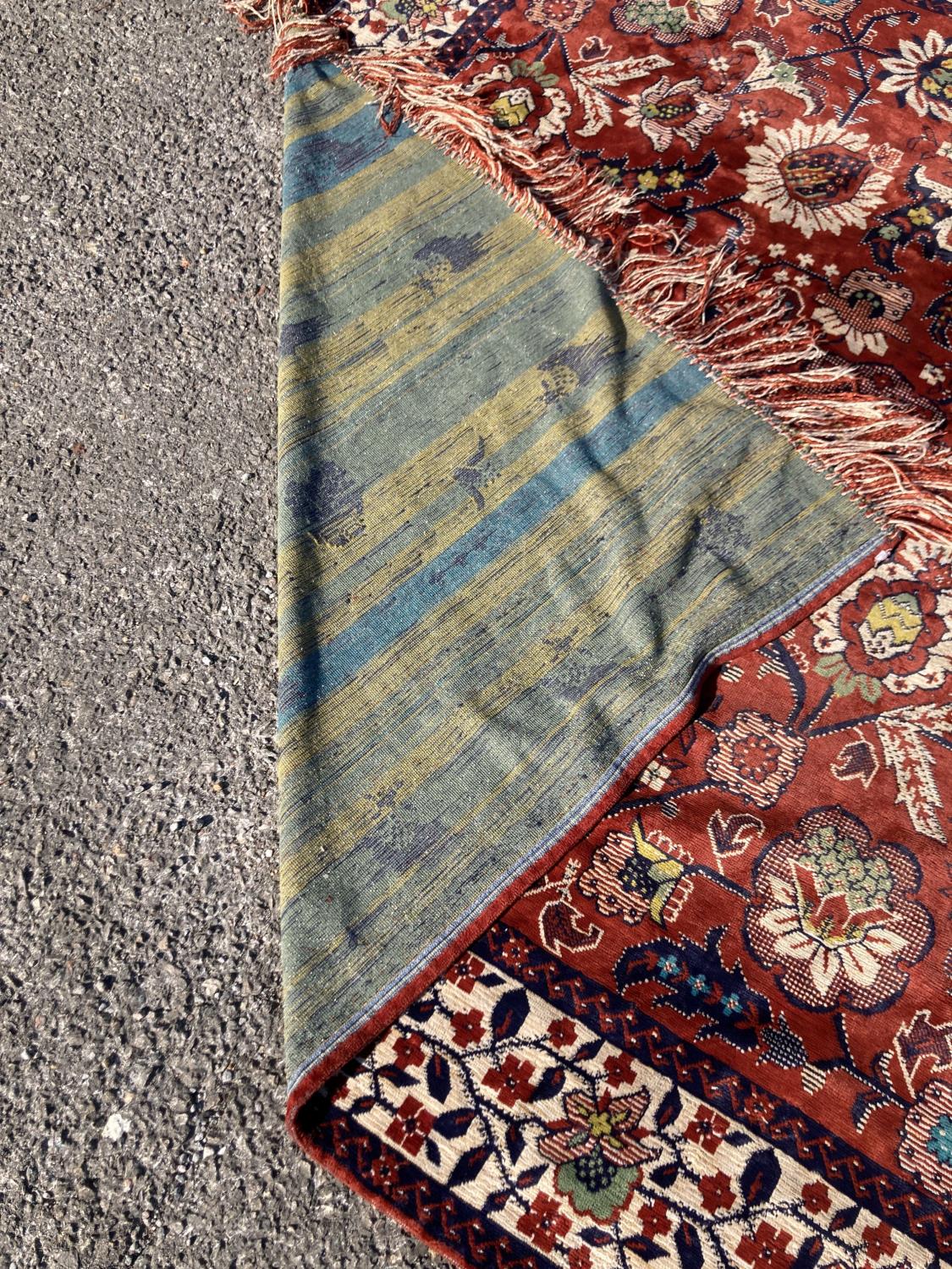 A large embroidered silk rug with a claret red ground interspersed with symmetrical foliate - Image 5 of 5