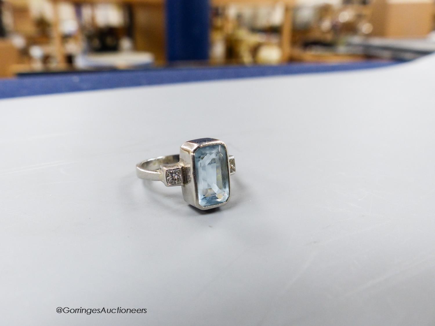 A modern platinum, aquamarine and diamond set three stone dress ring, size N, gross weight 6.8