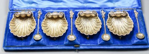 A cased set of four Victorian silver scallop shell salts, on dolphin feet, with four matching