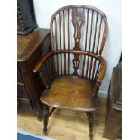 An early 19th century yew and elm Windsor armchair, with crinoline stretcher