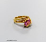 A modern 18k gold, emerald cut pink sapphire set dress ring, with graduated baguette cut diamond