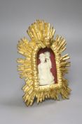 A carved ivory relief figure of a maiden emblematic of agriculture, in a giltwood sunburst frame,