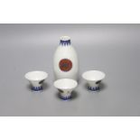 A Japanese blue and white porcelain sake flask, with associated cups, height 12cm