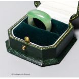 A Chinese jadeite ring, 19th/20th century,the carver skilfully incorporating the green inclusion in