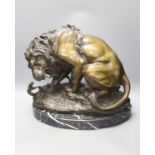 After Antoine-Louis Barye. A reproduction bronze of a tiger attacking a serpent, on a marble