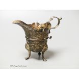 An 18th century Irish? silver cream jug, with later embossed decoration, marks rubbed, height 11.