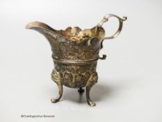 An 18th century Irish? silver cream jug, with later embossed decoration, marks rubbed, height 11.