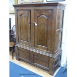 An early 18th century oak cupboard fitted a pair of arched fielded panelled doors, width 130cm,