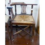 A mid 18th century oak rush seat corner elbow chair