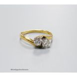 An 18ct and two stone diamond set crossover ring, size O, gross 2.6 grams,total diamond weight