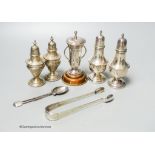 Two pairs of silver peppers, a small silver golfing trophy cup and a pair of silver sugar tongs and