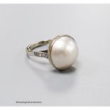 An 18ct white metal and mabe pearl set dress ring with diamond set shoulders, size N, gross 7.2