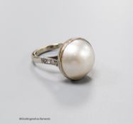 An 18ct white metal and mabe pearl set dress ring with diamond set shoulders, size N, gross 7.2