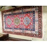 A Caucasian style red ground rug, 155 x 92cm