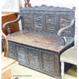 A late 19th century Flemish carved oak box seat settle, W.140cm D.62cm H.105cm